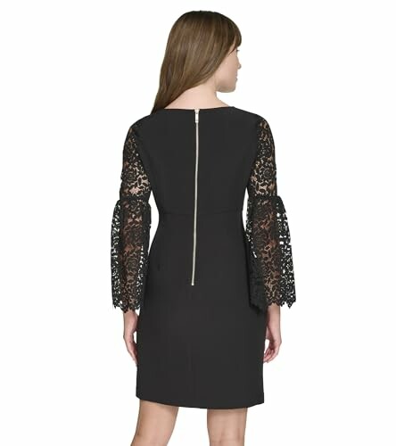 Mujer con vestido negro de manga de encaje vista desde atrás.