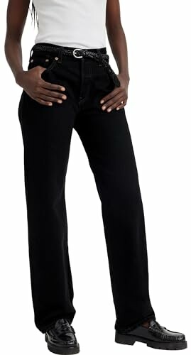 Persona con jeans negros y camisa blanca.