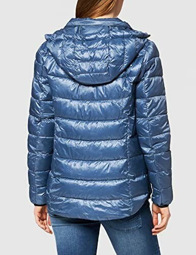 Mujer con chaqueta acolchada azul vista desde atrás.