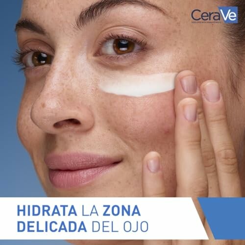 Mujer aplicando crema en el área del ojo.