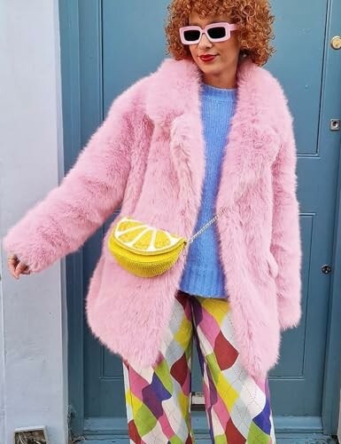 Persona con abrigo rosa, pantalones de cuadros y bolso de limón.