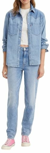 Persona con camisa y pantalones de mezclilla y zapatillas rosadas.