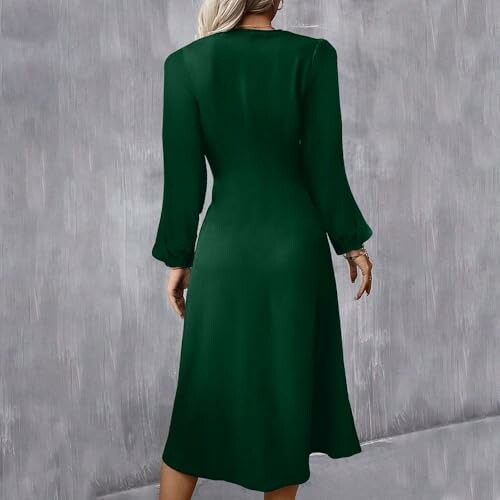 Mujer con vestido verde elegante de manga larga.