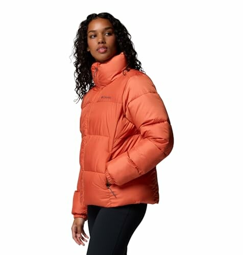 Mujer con chaqueta acolchada naranja.
