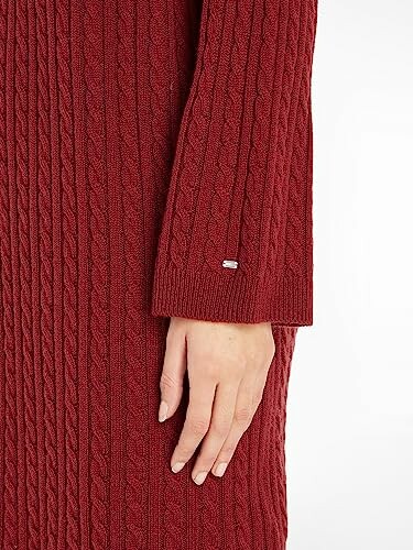 Manga de suéter de punto trenzado rojo con mano.