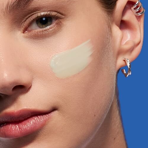 Mujer con crema facial en la mejilla.