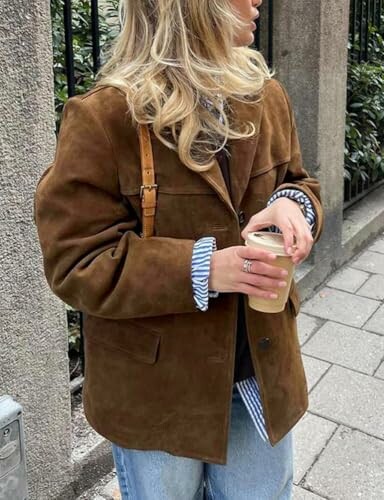 Mujer sosteniendo un café con chaqueta marrón