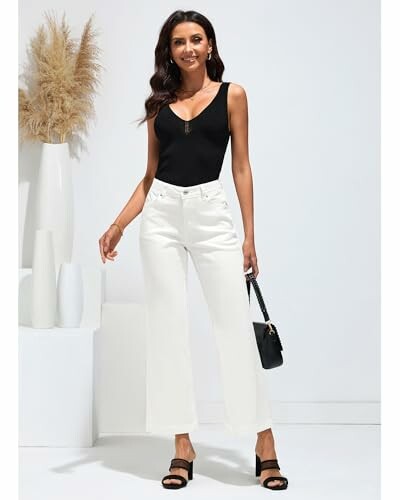 Mujer con pantalones blancos y top negro.