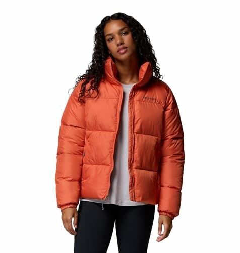 Mujer con chaqueta acolchada naranja.