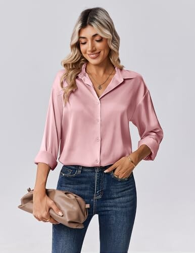 Mujer con camisa rosa y jeans sosteniendo un bolso.