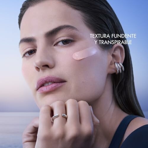 Mujer con crema en el rostro y fondo de mar