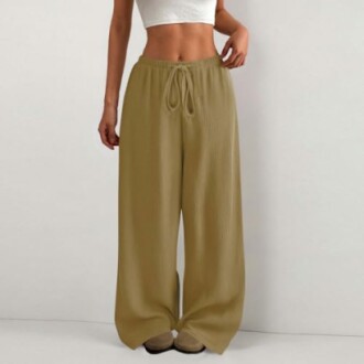 Mujer con pantalones anchos beige y top blanco.