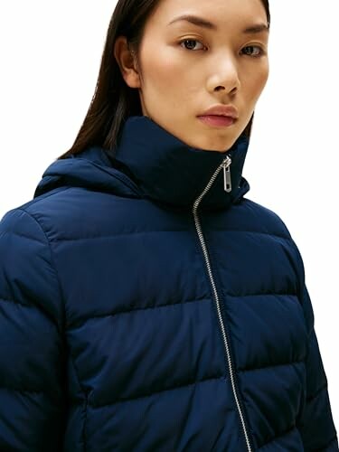 Mujer con chaqueta acolchada azul.