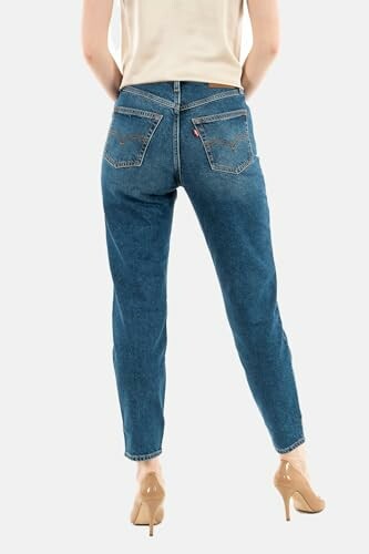 Mujer de espaldas vistiendo jeans azules y tacones